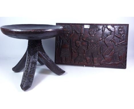 African tribal hardwood stool with three carved flared legs, H30cm and a similar panel carved with hunting scene, L51cm x H31