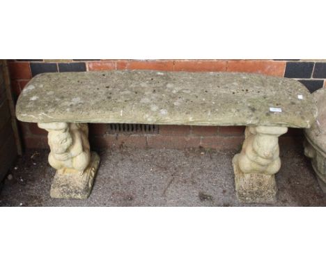 A reconstituted stone garden bench, raised upon squirrel supports