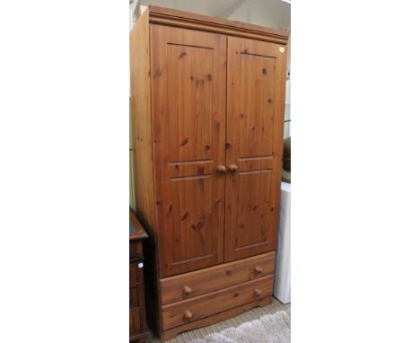 A modern pine two door wardrobe with two drawers to base