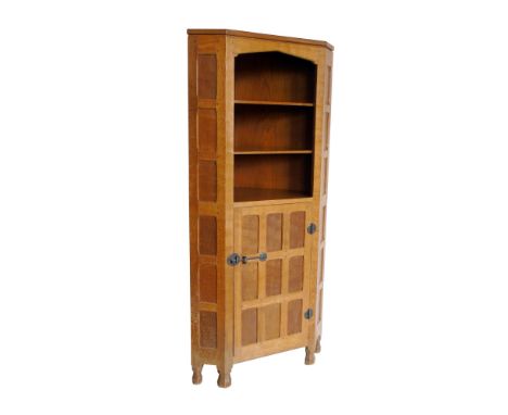 In the style of "Mouseman" there being no trademark mouse, floor standing corner cabinet, three open shelves above single doo