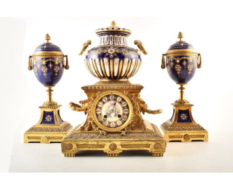 A late 19th century French ormolu and ceramic mantel clock and garnitures. The central clock is mounted with ormolu swags and