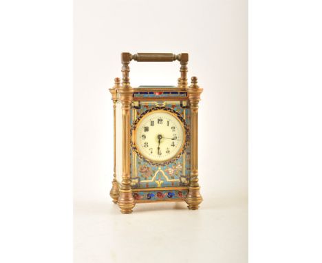 A late 19th century French champleve carriage clock. Fluted brass columns frame an enamel dial with Arabic numerals which is 