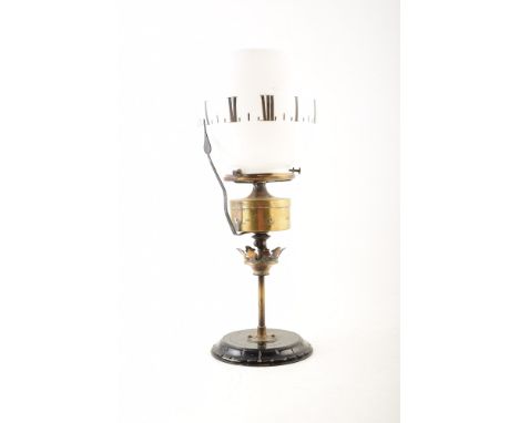 A Victorian 'clock' oil lamp. With white glass shade, acid etched with Roman numerals to denote a clock face. Brass case for 