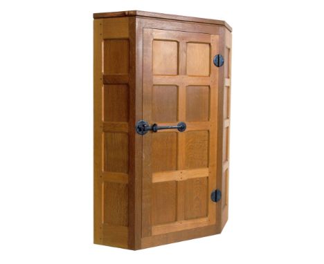 Robert "Mouseman" Thompson corner cupboard, eight panel single door with traditional wrought metal hinges and latch opening t