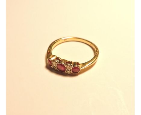 An 18ct gold three stone ruby ring, with pairs of diamonds between