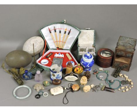 Two ostrich eggs, one engraved, the other plain with a stand, two hardstone snuff bottles, assorted netsuke, and Asian items