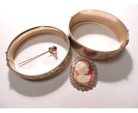 Two rolled gold hinged bangles, a gilt metal shell cameo brooch, and a 9ct gold garnet set flower stick pin