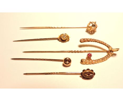A ruby and split pearl wishbone stick pin, marked 15ct, with a later pin tested as approximately 9ct gold, together with two 