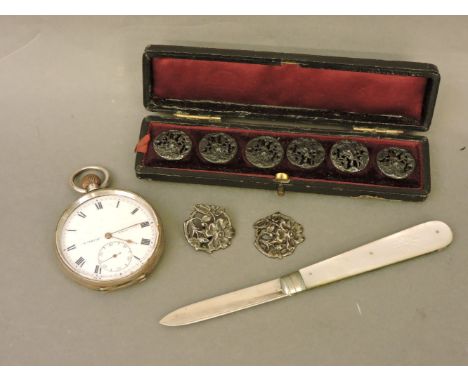 A silver open faced pocket watch, a silver fruit knife with mother of pearl handle, two Art Nouveau silver buttons, and a cas