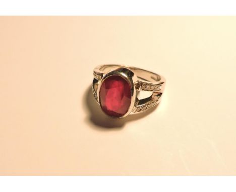 An 18ct white gold glass filled ruby ring, with diamond set shoulders