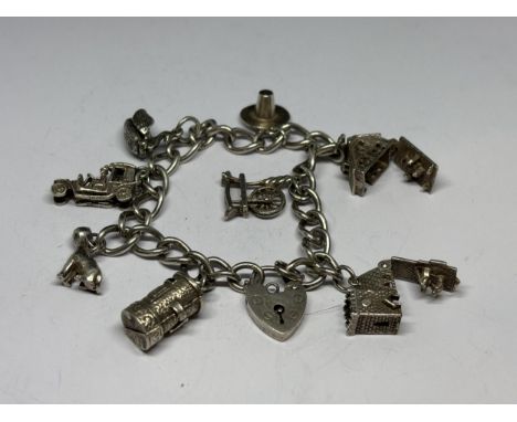 A SILVER CHARM BRACELET WITH EIGHT CHARMS AND A HEART PADLOCK