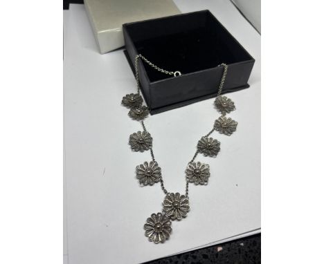 A SILVER FLOWER NECKLACE IN A PRESENTATION BOX