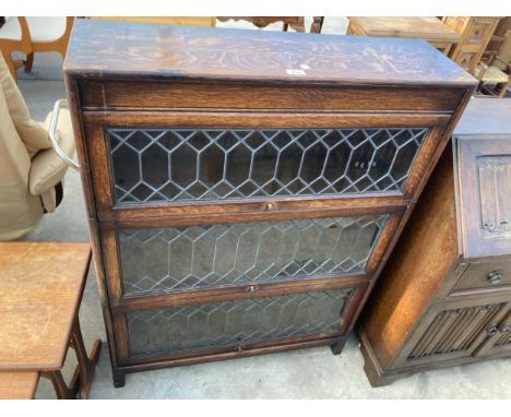 AN EARLY 20TH CENTURY OAK GLOBE WERNIKE STYLE THREE TIER GLAZED AND LEADED THREE TIER BOOKCASE, 34" WIDE
