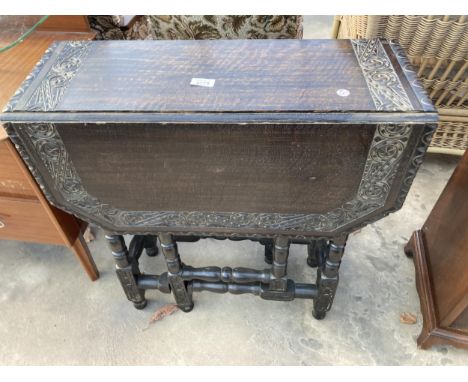 AN EARLY 20TH CENTURY HEAVILY CARVED OAK GATE LEG TABLE ON TURNED LEGS, 33" X 26" OPENED