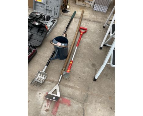 A SMALL WATERING CAN AND THREE GARDEN TOOLS TO INCLUDE A HOE ETC