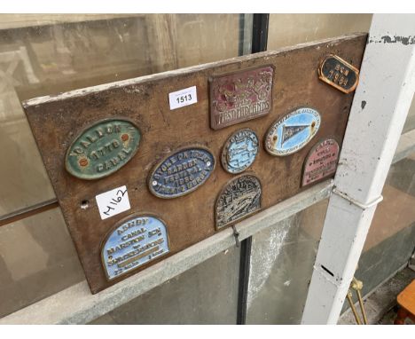 A WOODEN BOARD CONTAINING VARIOUS VINTAGE CAST FESTIVAL PLAQUES