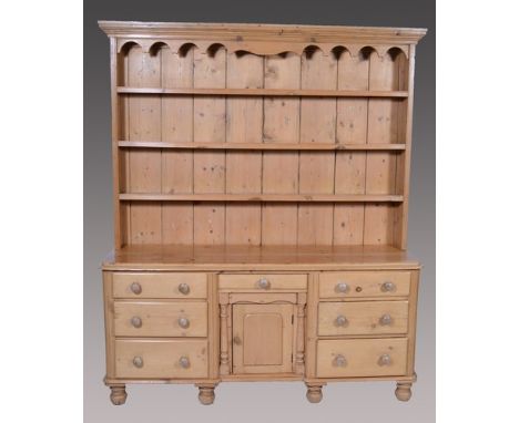 Stripped pine dresser, matched three shelf delft rack, the base with recessed centre drawer over a cupboard, flanked by banks