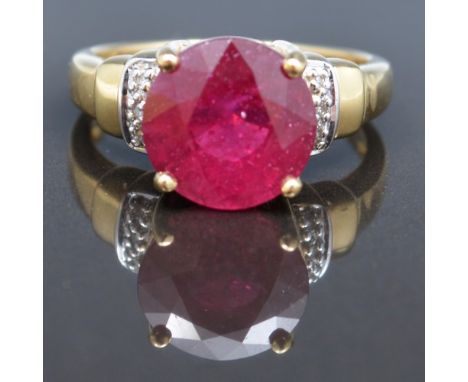 18ct hallmarked gold dress ring, set with a ruby coloured stone and with small diamonds to the shoulders.