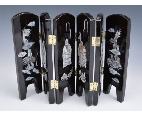 Two tortoiseshell and abalone inlaid panels, mounted and framed, 12cm x 10cm overall, a small lacquered six fold screen, a mo