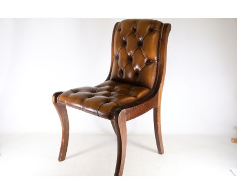 Regency-Style Leather Upholstered Chair  A Regency-style chair featuring antique tan leather upholstery with a Chesterfield-i