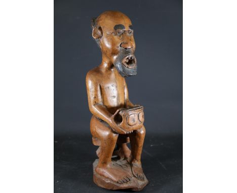 Carved Wooden Seated Figure, Likely African Tribal Sculpture  A hand-carved wooden figure depicting a seated humanoid form, p