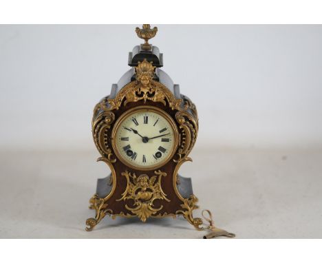 19th Century French Rococo-Style Mantel Clock  This 19th-century French Rococo-style mantel clock is crafted from a combinati