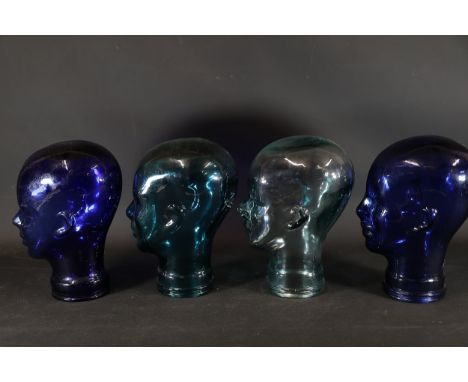 Set of Four Glass Display Heads  A set of four glass mannequin-style head displays, likely designed for showcasing hats, wigs