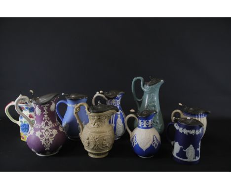 **Collection of Nine Vintage Ceramic Pouring Jugs with Spelter Lids**A diverse group of nine vintage ceramic pouring jugs, ea