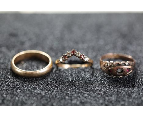 Three Gold or Gold-Toned RingsThis collection includes three rings of distinct designs:1. **Plain Wedding Band:** A tradition