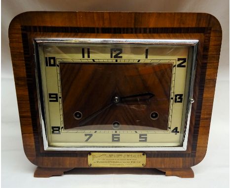 An Art Deco Mantel Clock with "British Anvil" movement and rod strike in a walnut case with presentation plaque.  10 1/2" (27