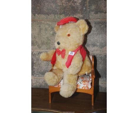 A vintage Teddy bear pyjama case on wooden seat.