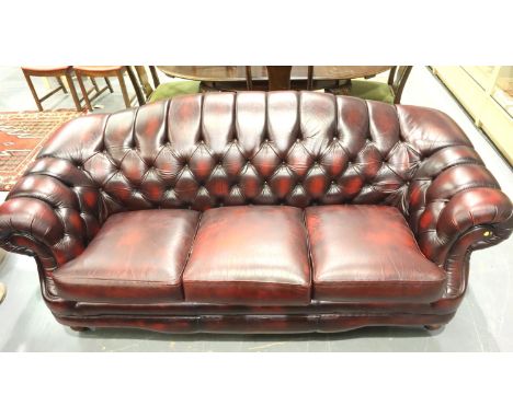 Thomas Lloyd modern three seat sofa in oxblood red leather, buttoned in the Chesterfield style, 210 x 90 x 85 cm H. Not avail