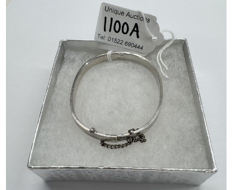 A silver bangle with safety chain