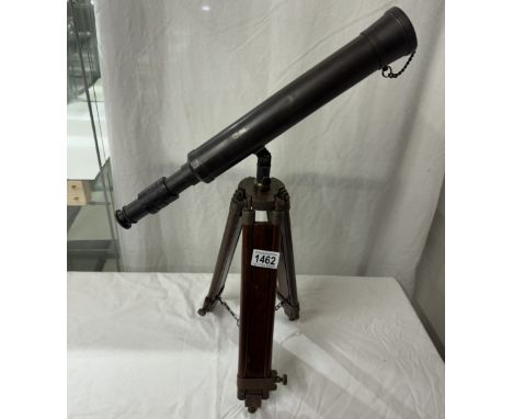 A patinated brass telescope on tripod base. Length 43cm