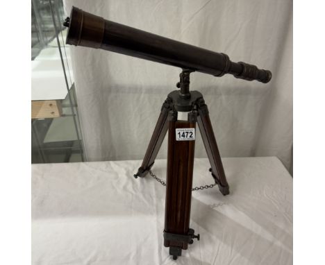 A patinated brass telescope on tripod base. Length 43cm