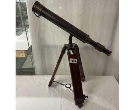 A patinated brass telescope on tripod base. Length 43cm