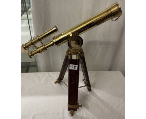 A polished brass telescope on tripod base. Length 43cm