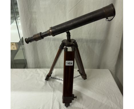 A patinated brass telescope on tripod base. Length 43cm