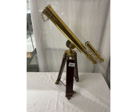 A polished brass telescope on tripod base. Length 43cm