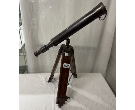 A patinated brass telescope on tripod base. Length 43cm