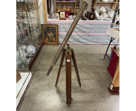 A patinated brass telescope on tripod base. Length 98cm.