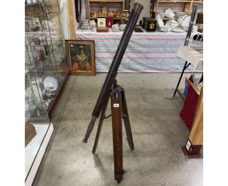 A patinated brass telescope on tripod base. Length 98cm.