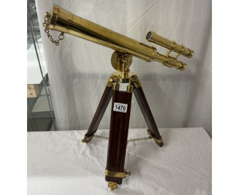 A polished brass telescope on tripod base. Length 43cm