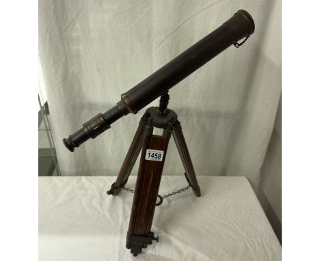 A patinated brass telescope on tripod base. Length 43cm