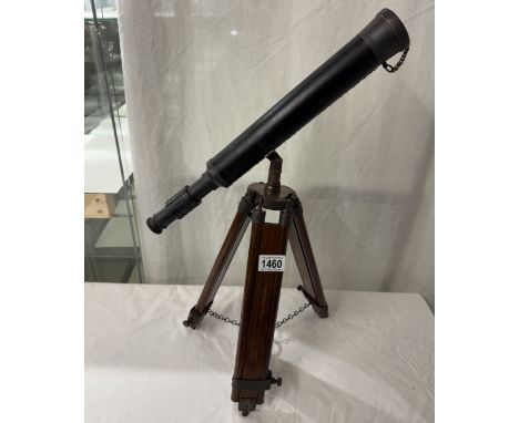 A patinated brass telescope on tripod base. Length 43cm