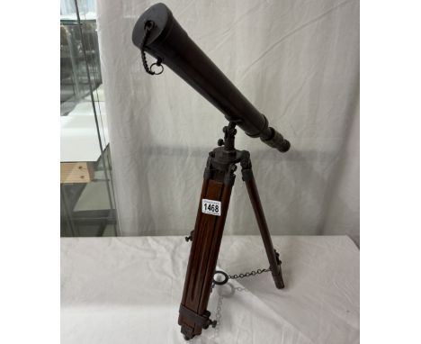 A patinated brass telescope on tripod base. Length 43cm