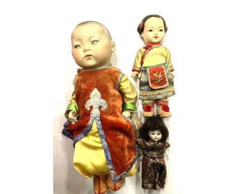 An Armand Marseille bisque Oriental boy doll, in colourful traditional clothing, marked 353/3 1/2K to nape.With two smaller u