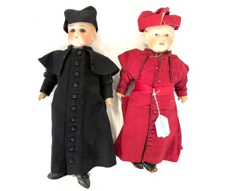 Two dolls with bisque heads dressed as Catholic Cardinals in red and black respectively33 cm long