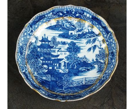 A Caughley saucer dish, circa 1785-90, transfer printed in underglaze blue with the Pagoda pattern, enriched with gilding, pr