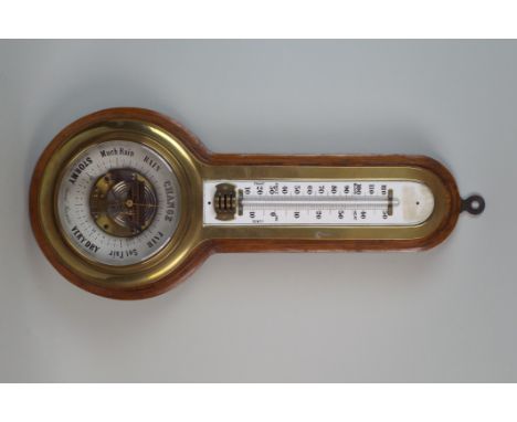 An brass cased aneroid barometer the 7¼ inch printed register under a mercury thermometer with arched top indistinctly signed